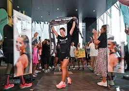 Nat crossing the finish line with arms raised in celebration