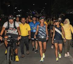 Nat running at night with support crew and community